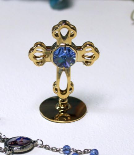 Cruz de ouro da coleção Precious da FITALONLINA com cristal austríaco azul em um estande